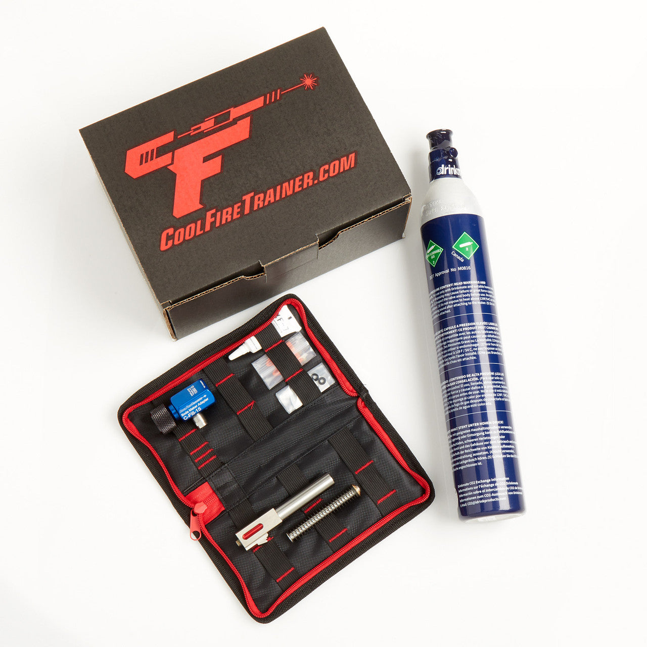 CoolFire Trainer dry-fire kit laid out showing branded box, CO2 cylinder, zippered accessories pouch with barrel and components