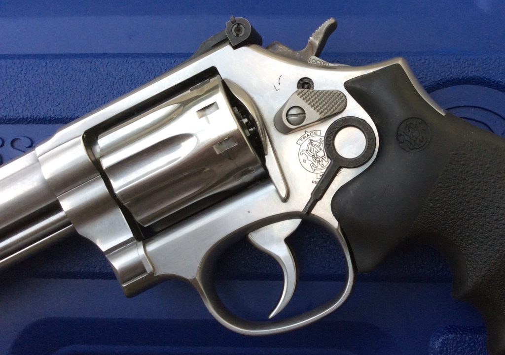 Smith & Wesson 686 stainless revolver showing internal lock keyhole above cylinder release, black rubber grips