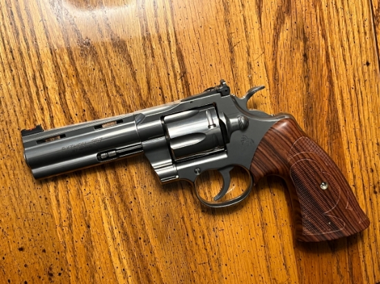 Blued large-frame revolver with wood grips and adjustable rear sight on a wooden surface