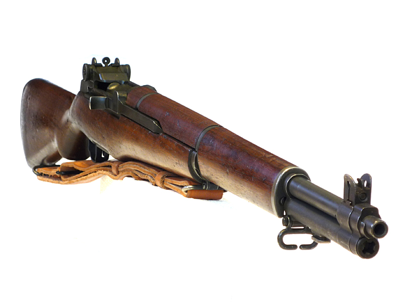 M1 Garand semi-automatic rifle with walnut stock and leather sling, shown on a white background.