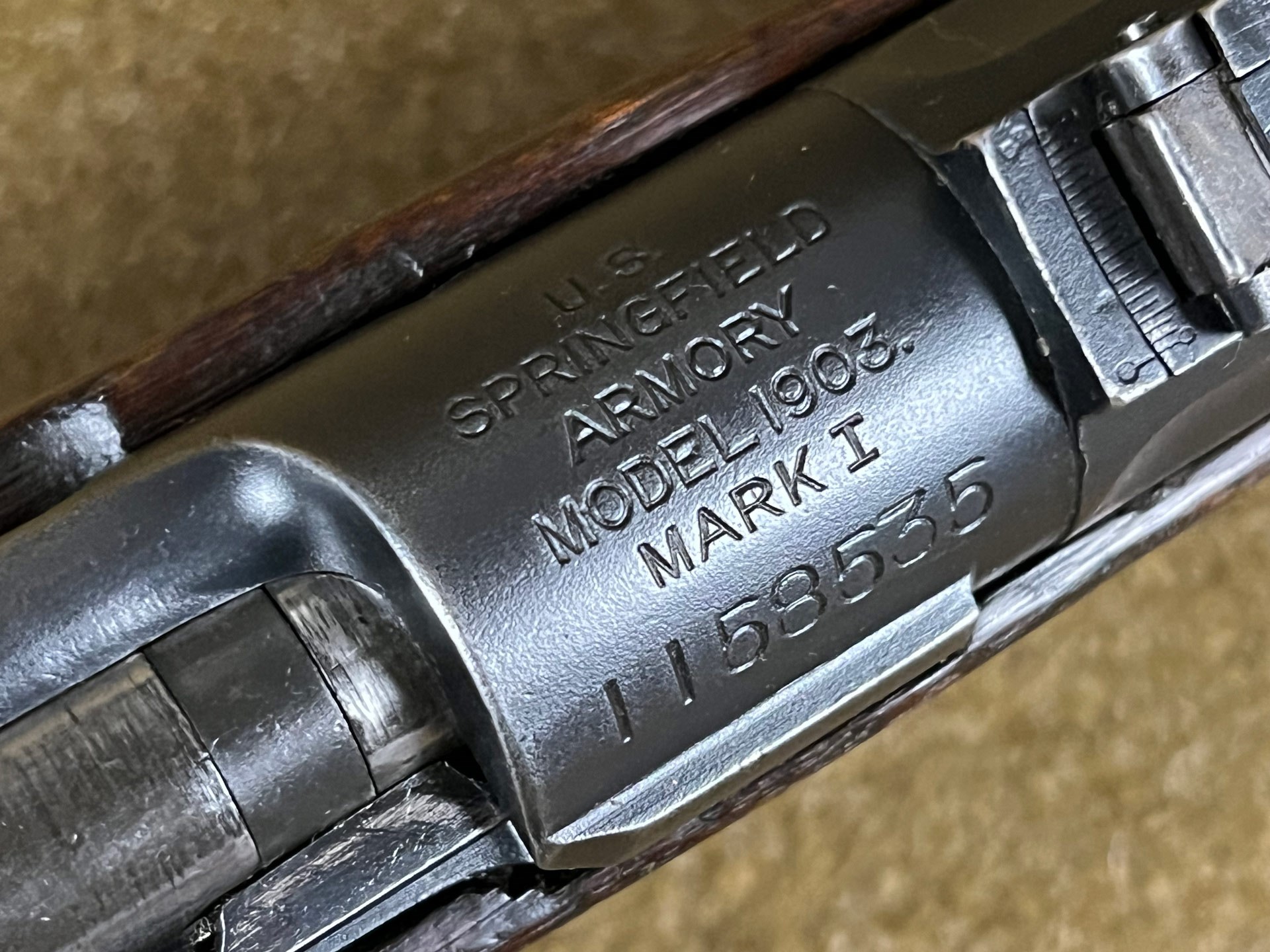 Close-up of a Springfield Armory Model 1903 Mark I rifle receiver showing stamped manufacturer markings and serial number.
