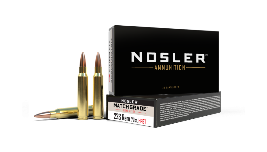 Box of Nosler Match Grade 223 Rem 77 grain HPBT ammunition with two loose cartridges standing upright beside it on a white background.