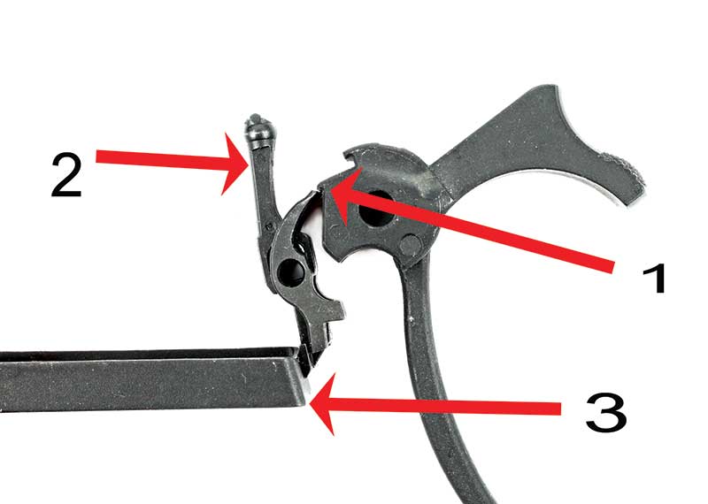 Close-up diagram of a 1911-style fire control group with red arrows labeling the hammer, disconnector, and sear components against a white background.