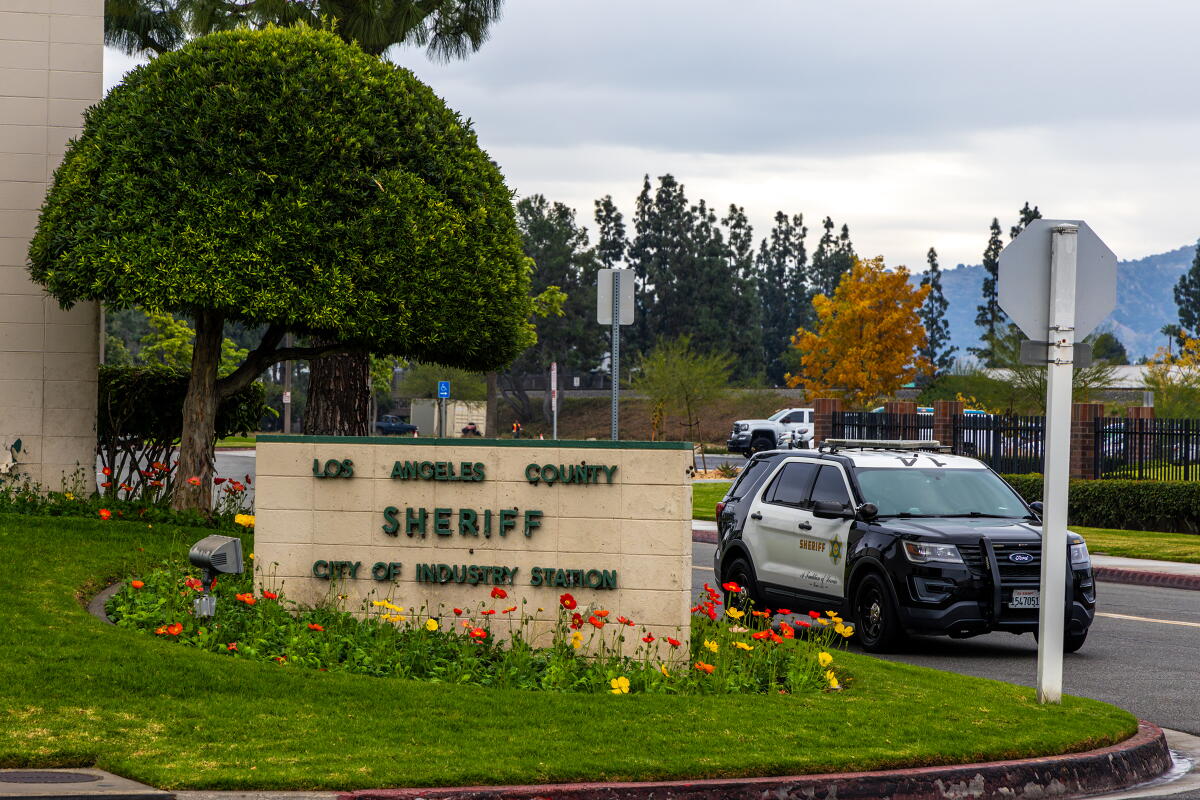 Los Angeles County Sheriff City of Industry Station sign with a marked LASD Ford Police Interceptor Utility vehicle in the background.