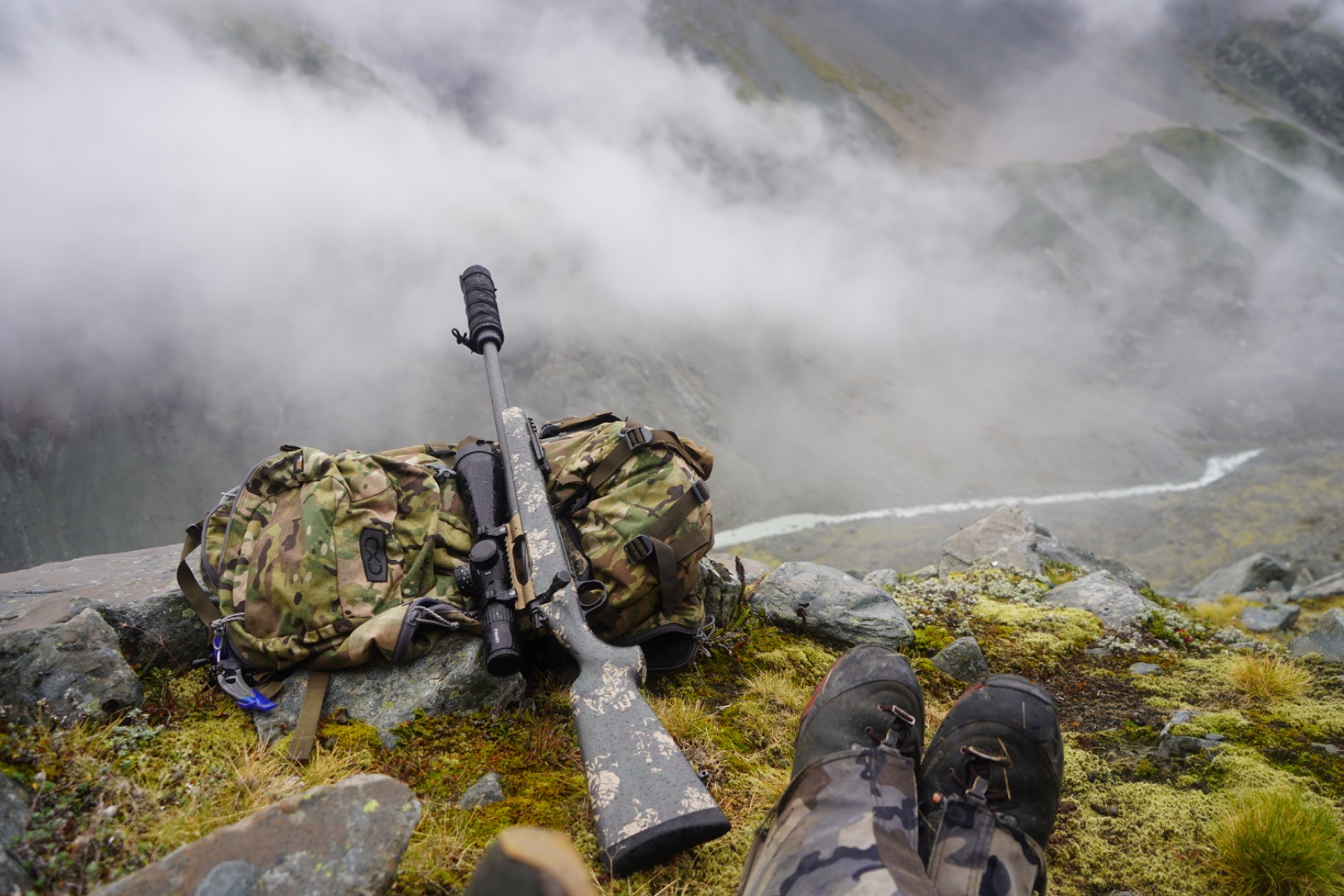 A hunter in rugged mountain terrain.