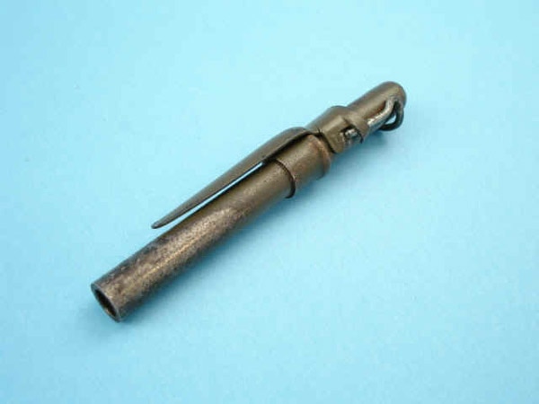 A small metal pen gun with a tubular barrel and exposed striker mechanism lying on a light blue background.