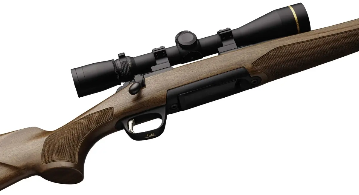 Browning X-Bolt bolt-action rifle with walnut stock and checkering, fitted with a Leupold riflescope in low-profile rings, shown against a white background.