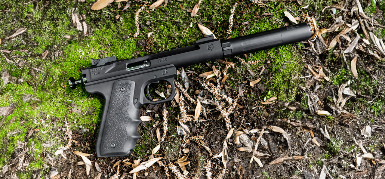 Suppressed .22 LR pistol with a Banish 22 silencer lying on mossy ground