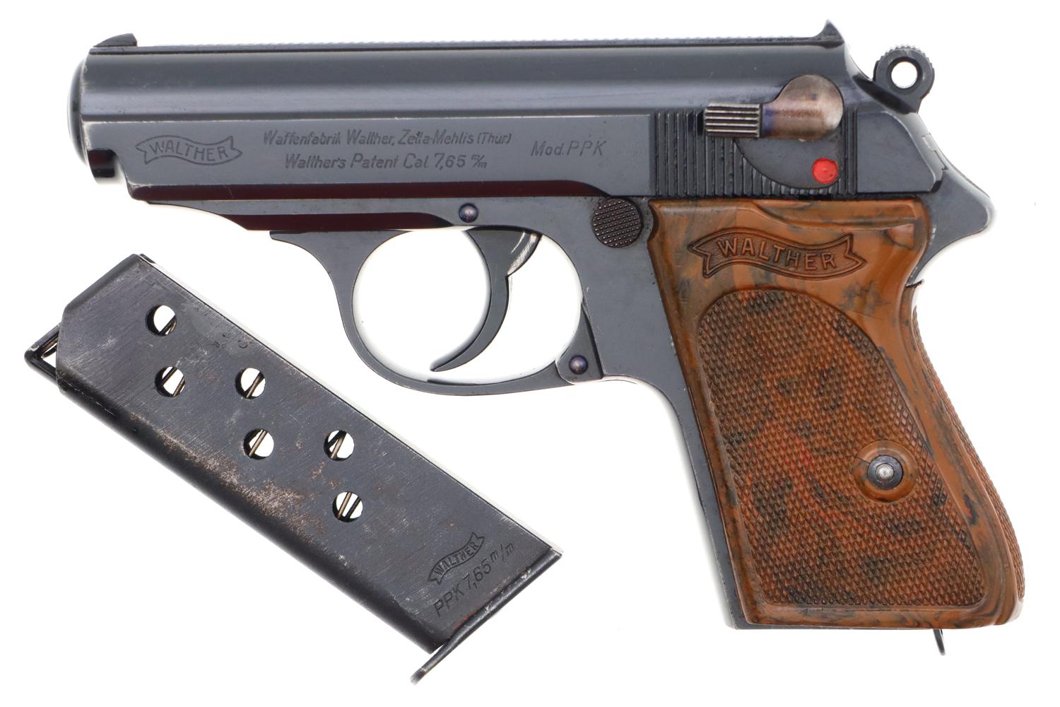 Pre-war Walther PPK semi-automatic pistol in 7.65mm with brown checkered grips and detached magazine on white background.