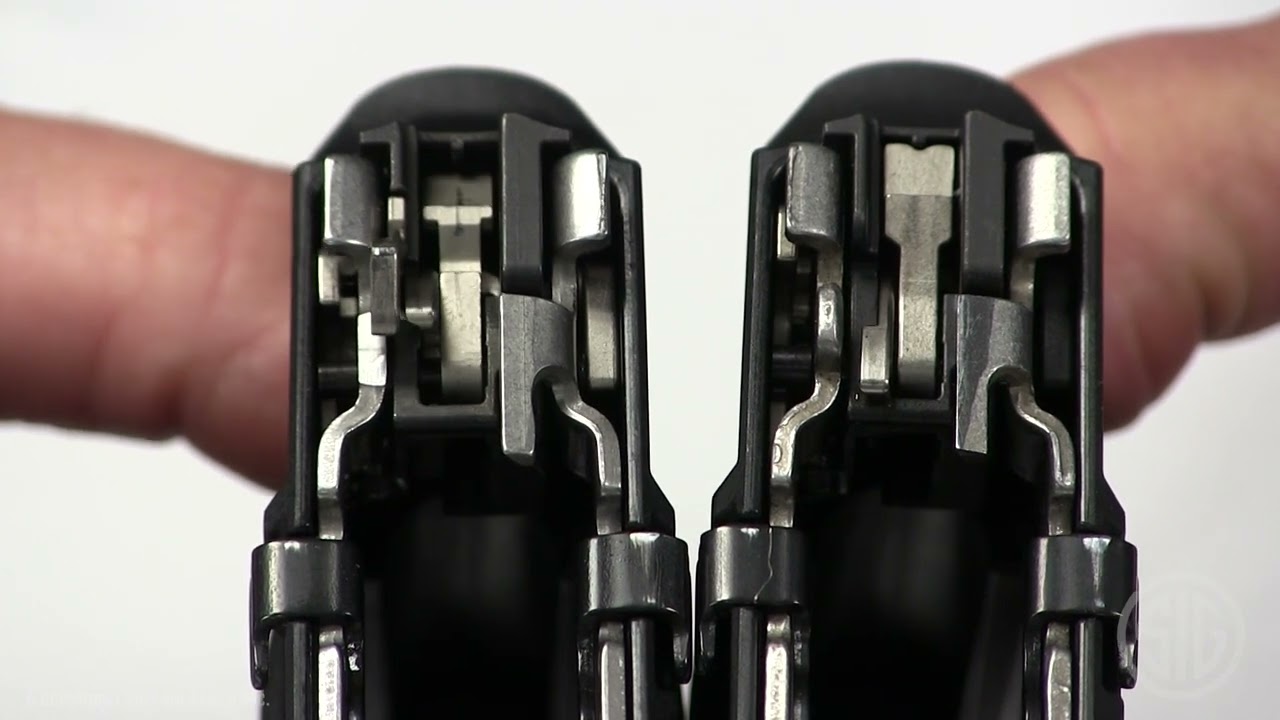 Close-up muzzle-end view of two disassembled P320 fire control groups held side by side, showing internal striker and sear components for comparison.