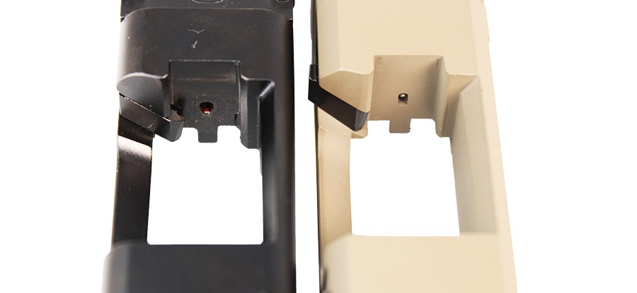 Bottom view of two SIG P320 slides side by side, one black and one FDE, showing the striker safety plunger recess near the breech face.
