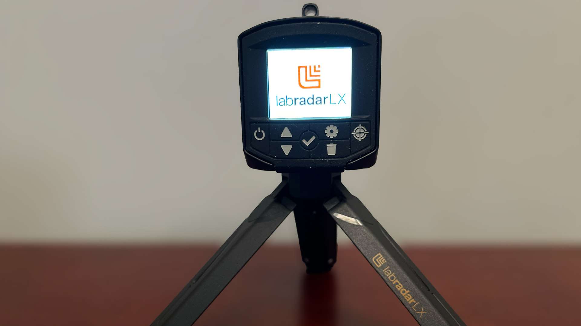 LabRadar LX Doppler radar chronograph on mini tripod showing startup screen with brand logo