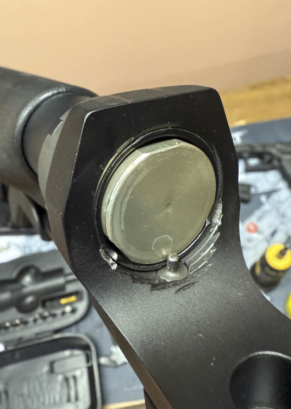 End-on view of a damaged AR-10 component showing a cracked polymer interior, illustrating gas system wear