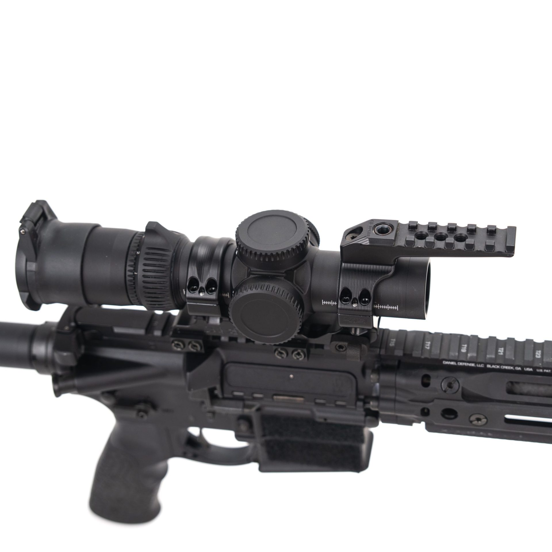 Close-up of a Daniel Defense AR-15 receiver and handguard with a magnified scope mounted in a cantilever ring on a Picatinny rail.