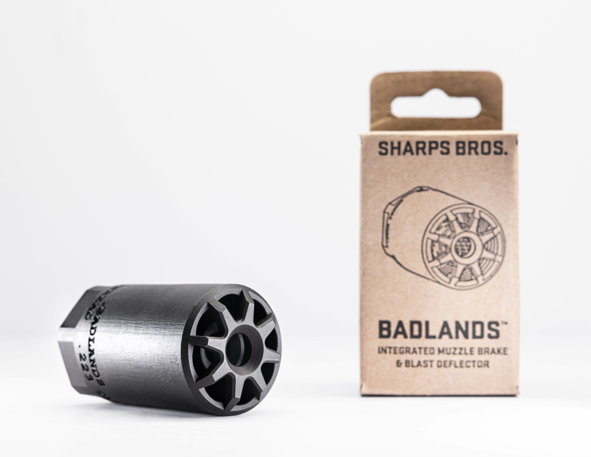 Sharps Bros. Badlands .223 muzzle brake and blast deflector next to its kraft cardboard retail box