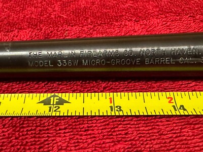 Close-up of a Marlin Model 336W barrel showing stamped text reading 'The Marlin Firearms Co. North Haven' and 'Model 336W Micro-Groove Barrel' with a measuring tape for scale.