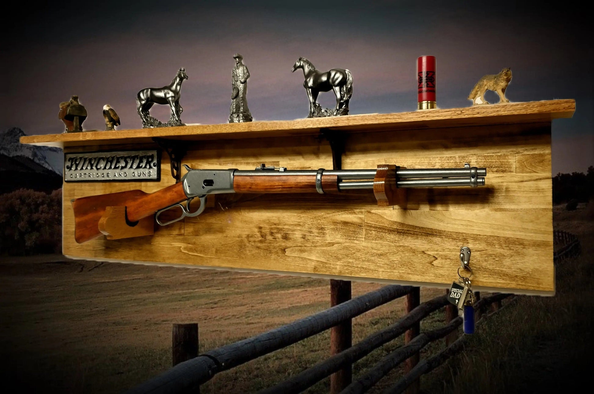 Winchester lever-action rifle mounted on a rustic wood wall rack with a Winchester Cartridge and Guns cast iron plaque, decorated with pewter Western figurines and a shotgun shell.