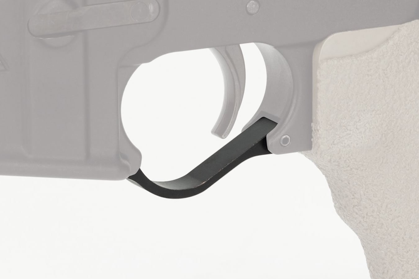 Close-up of a black 3D-printed oversized trigger guard installed on a gray AR-15 lower receiver with pistol grip visible.