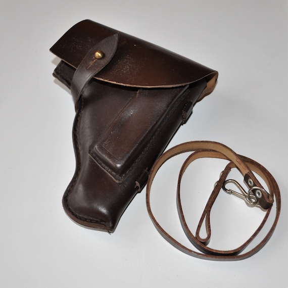Brown leather Cold War-era military pistol holster with snap closure and lanyard strap, possibly for a Makarov PM