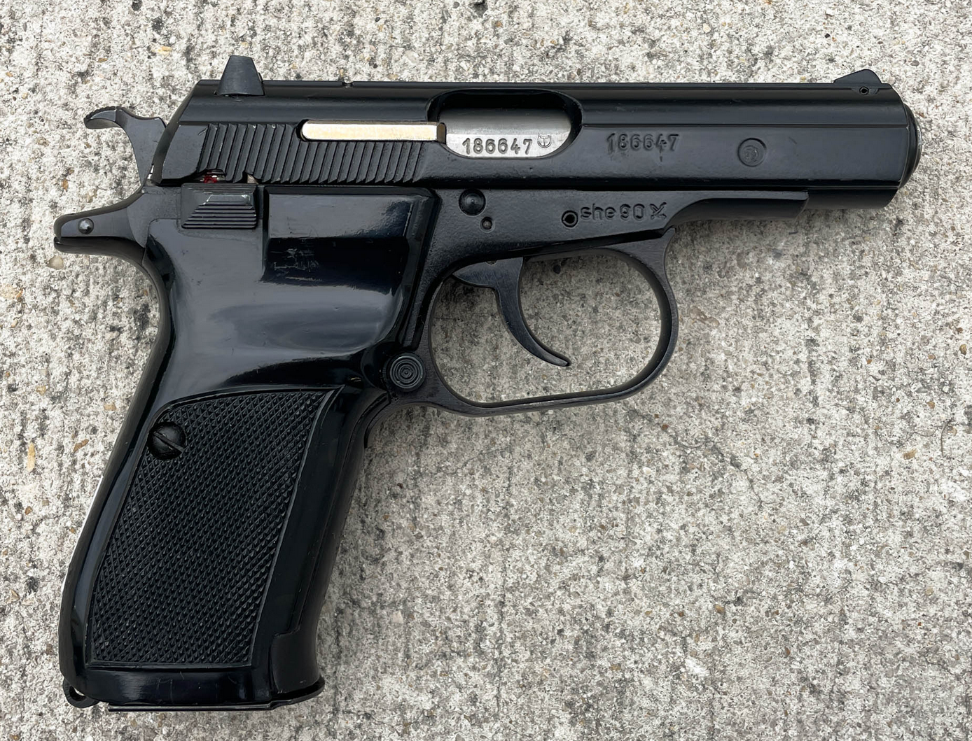 CZ 82 surplus pistol in black enamel finish, left side view, serial number 186647, on concrete surface