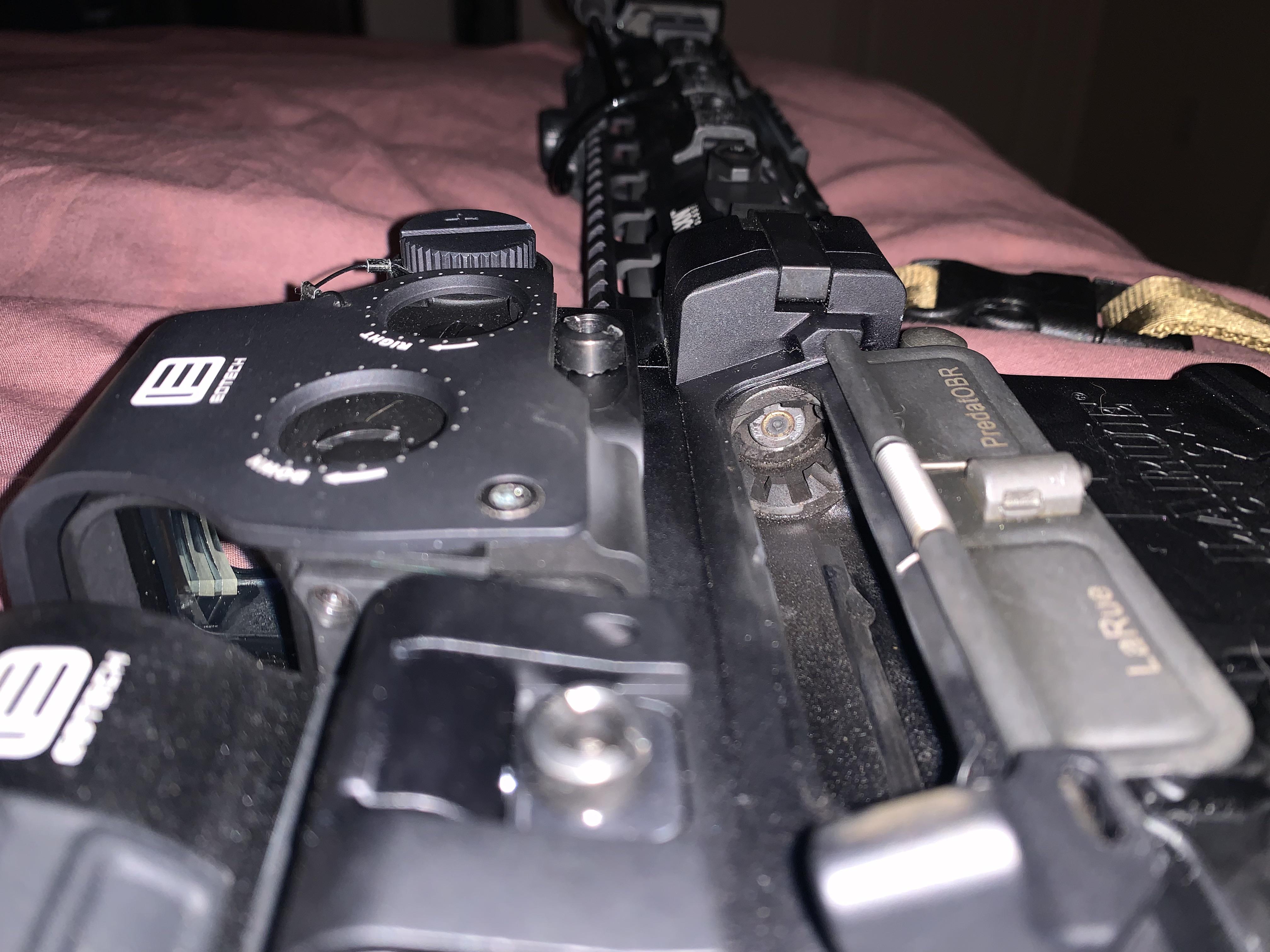 Close-up of an AR-platform rifle upper receiver showing an EOTech EXPS holographic sight on a LaRue Tactical PredatOBR rail, viewed from the left side at low angle.