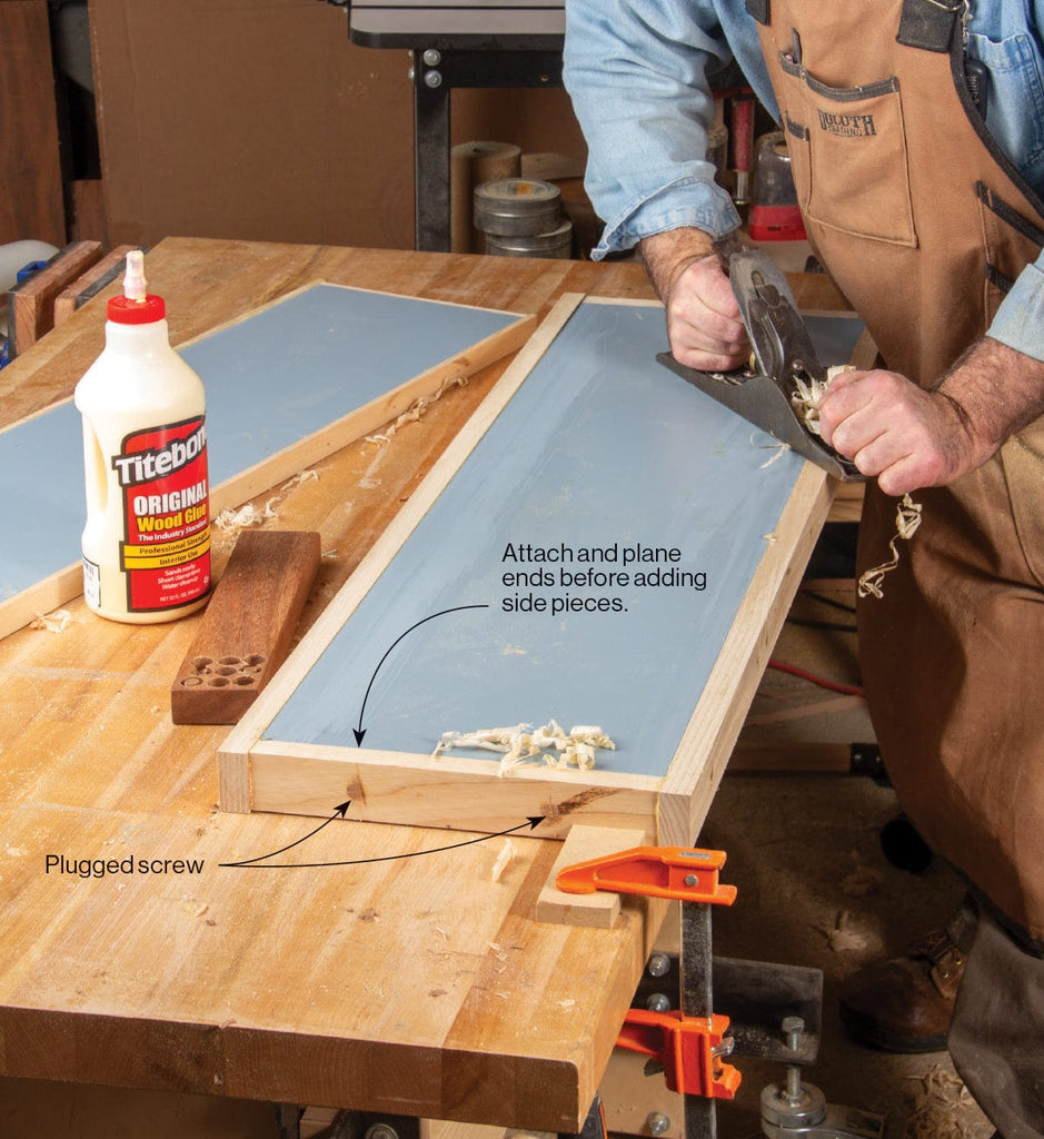 Woodworker using a hand plane on a framed wood panel clamped to a workbench, with a bottle of Titebond wood glue visible alongside.