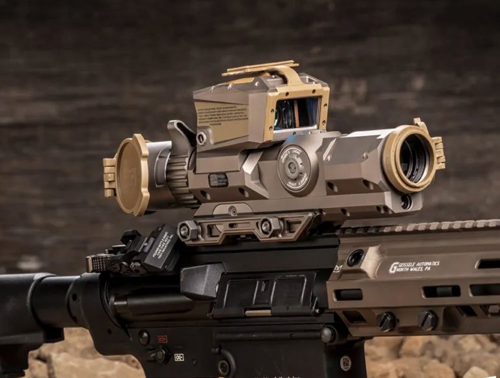 XM157 Fire Control optic with integrated red dot sight mounted on an AR-pattern rifle with a Geissele Automatics handguard, shown in flat dark earth finish.