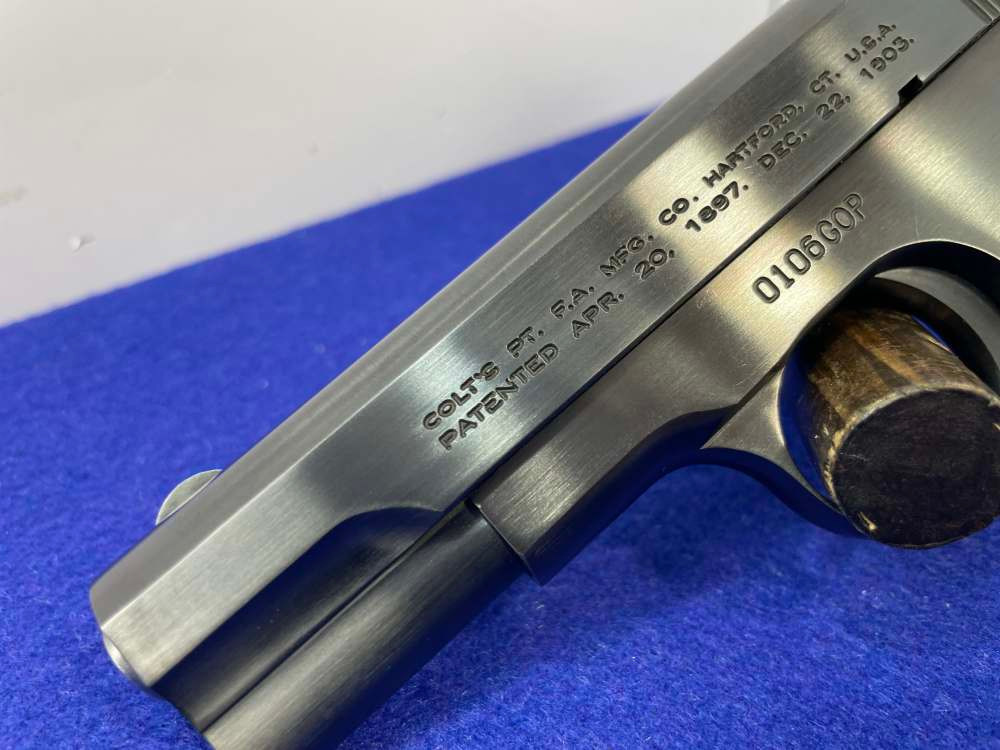 Close-up of a Colt 1903 Pocket Hammerless slide showing factory rollmarks with Hartford CT address and patent dates, with a bright nickel or stainless finish.