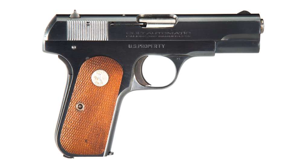 Left-side view of a blued Colt Model 1903 Pocket Hammerless pistol with U.S. Property marking on the frame and checkered walnut grips with a Colt rampant pony medallion.