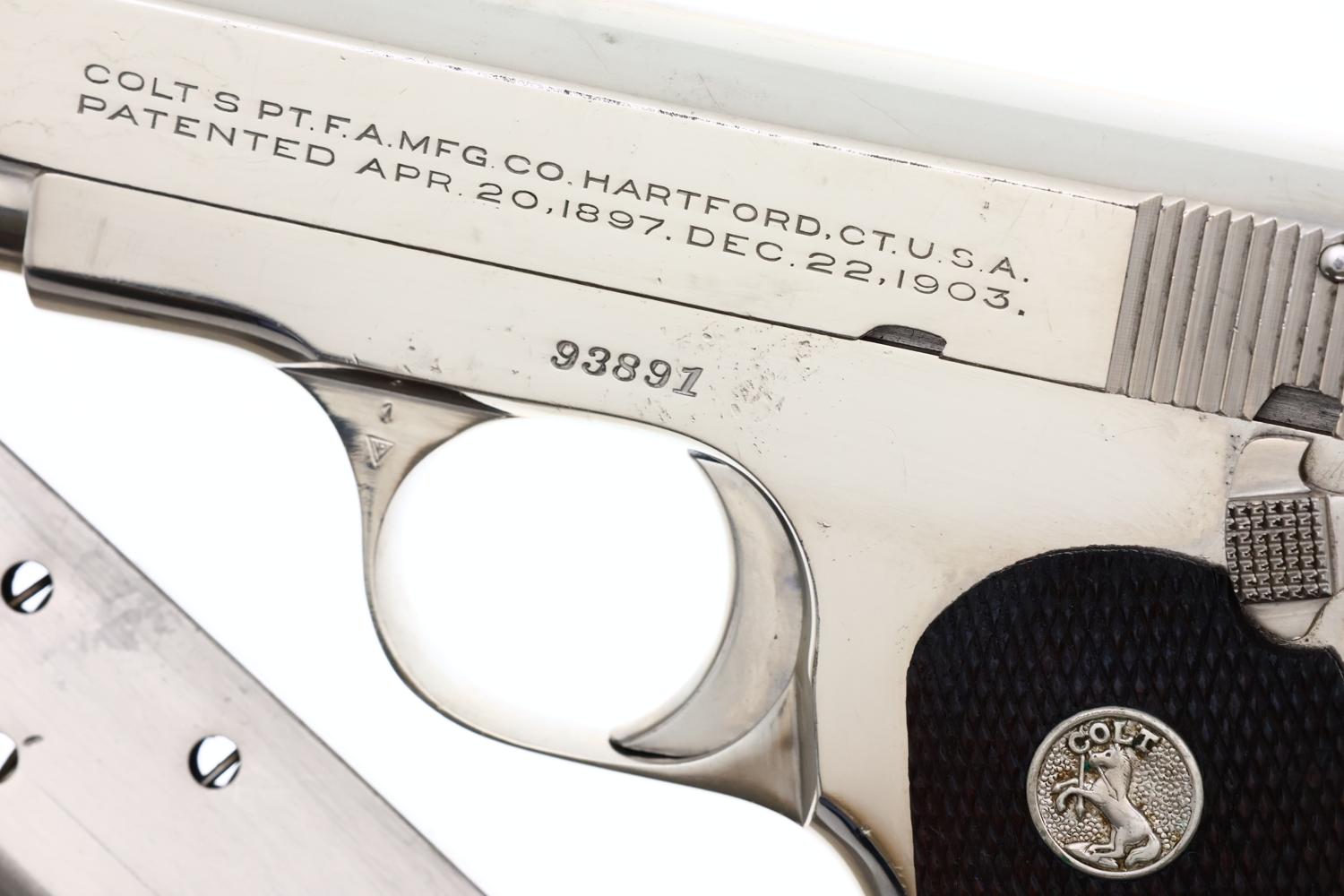 Close-up of a nickel-finished Colt semi-automatic pistol showing slide markings, serial number 93891, and checkered grip with Colt medallion.