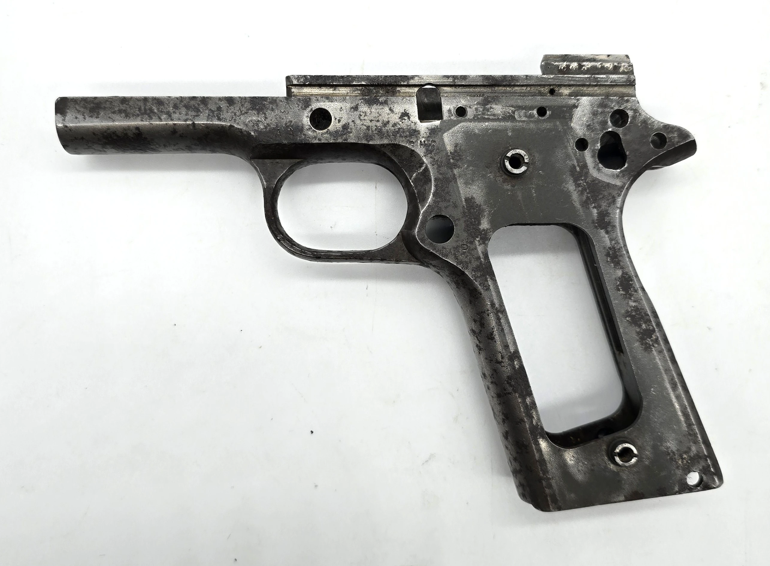 Bare metal Colt 1903 Pocket Hammerless pistol frame stripped of all components, showing trigger guard, grip frame cutout, and machined surfaces.